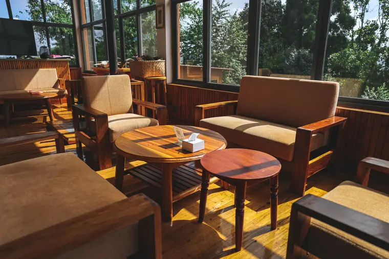 Comfortable chairs and small tables in the sunlit Fikkal Bar
