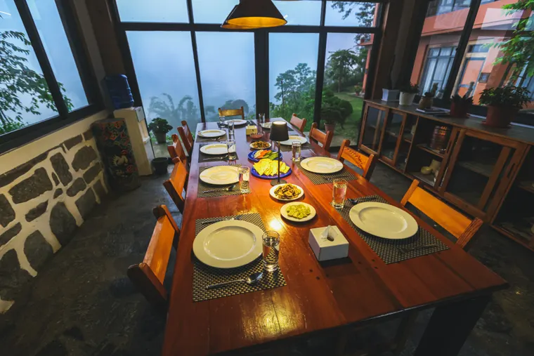 A long dining table set with food in Suryodaya Kitchen