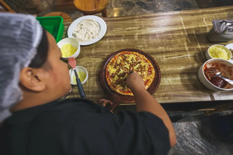 A member of the kitchen team preparing food with fresh ingredients