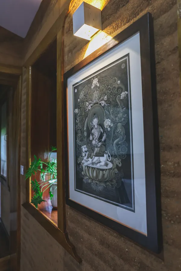 Framed monochrome artwork along a warm earthen wall
