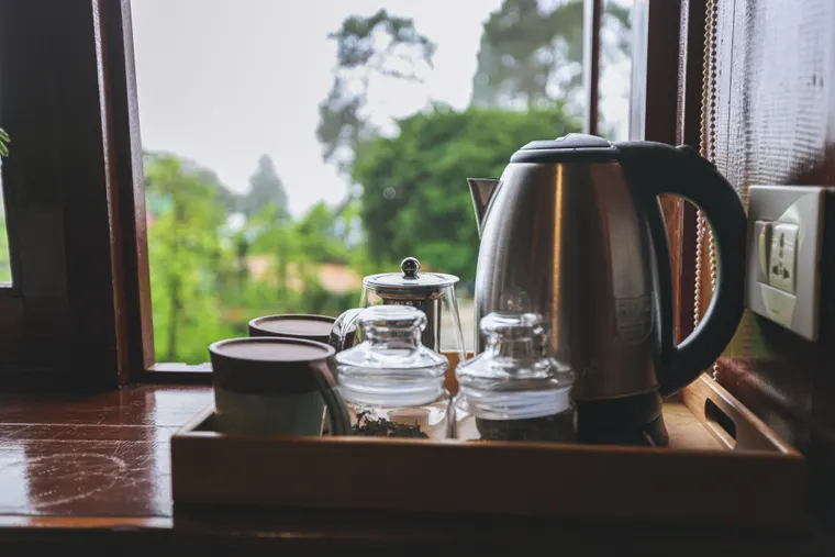 A tea tray and kettle beside a bright open window
