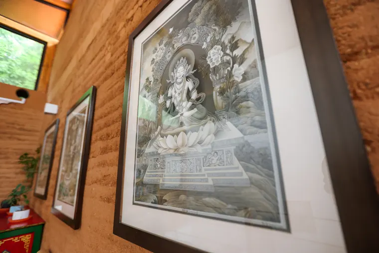 Framed traditional art displayed on an earthen wall