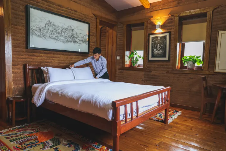 A king bed, timber furniture and traditional artwork in a guest room