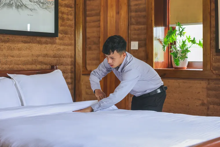 Careful preparation of fresh white bedding by the villa team